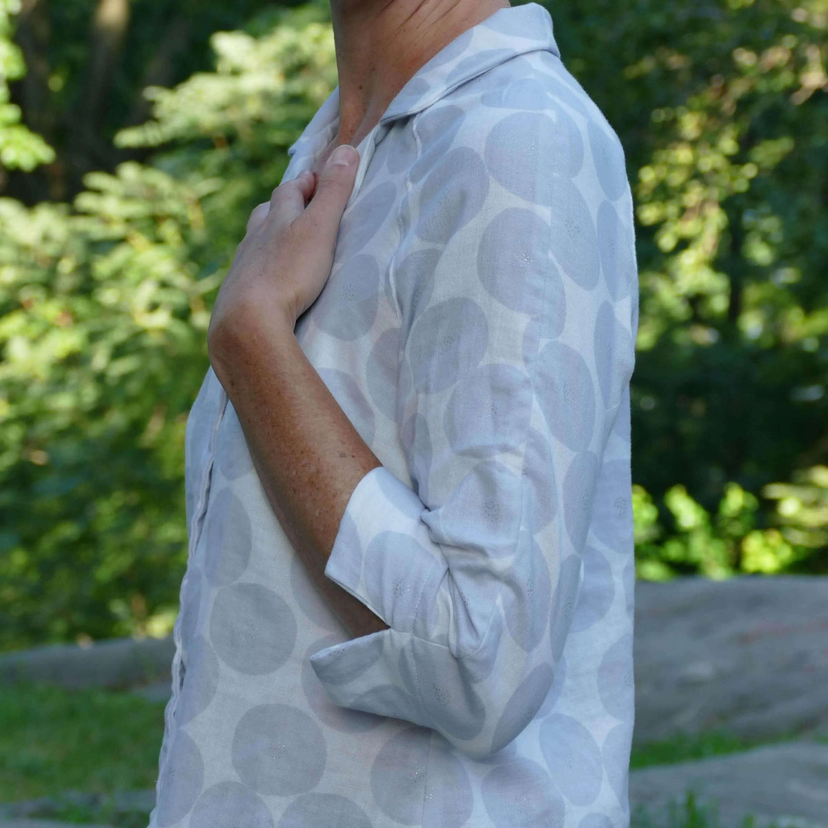 Tropicana shirt Paper Pattern showcasing 3/4-length raglan sleeves and relaxed fit in a beautiful outdoor setting.