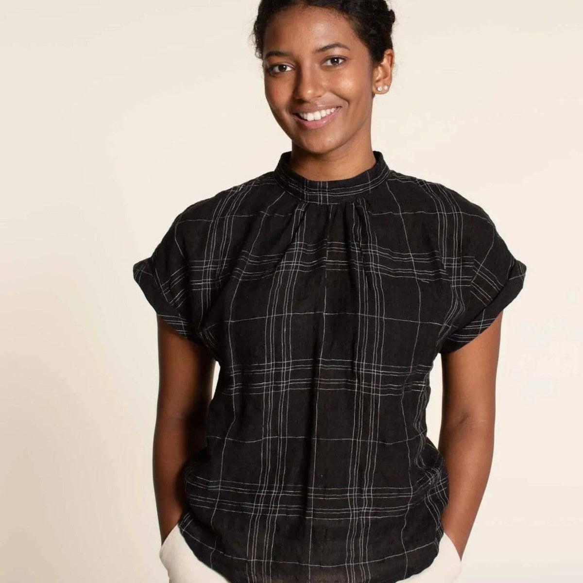 Model wearing the Tulip Top Paper Pattern, a cute woven top with gathered neckline and dolman shoulders.