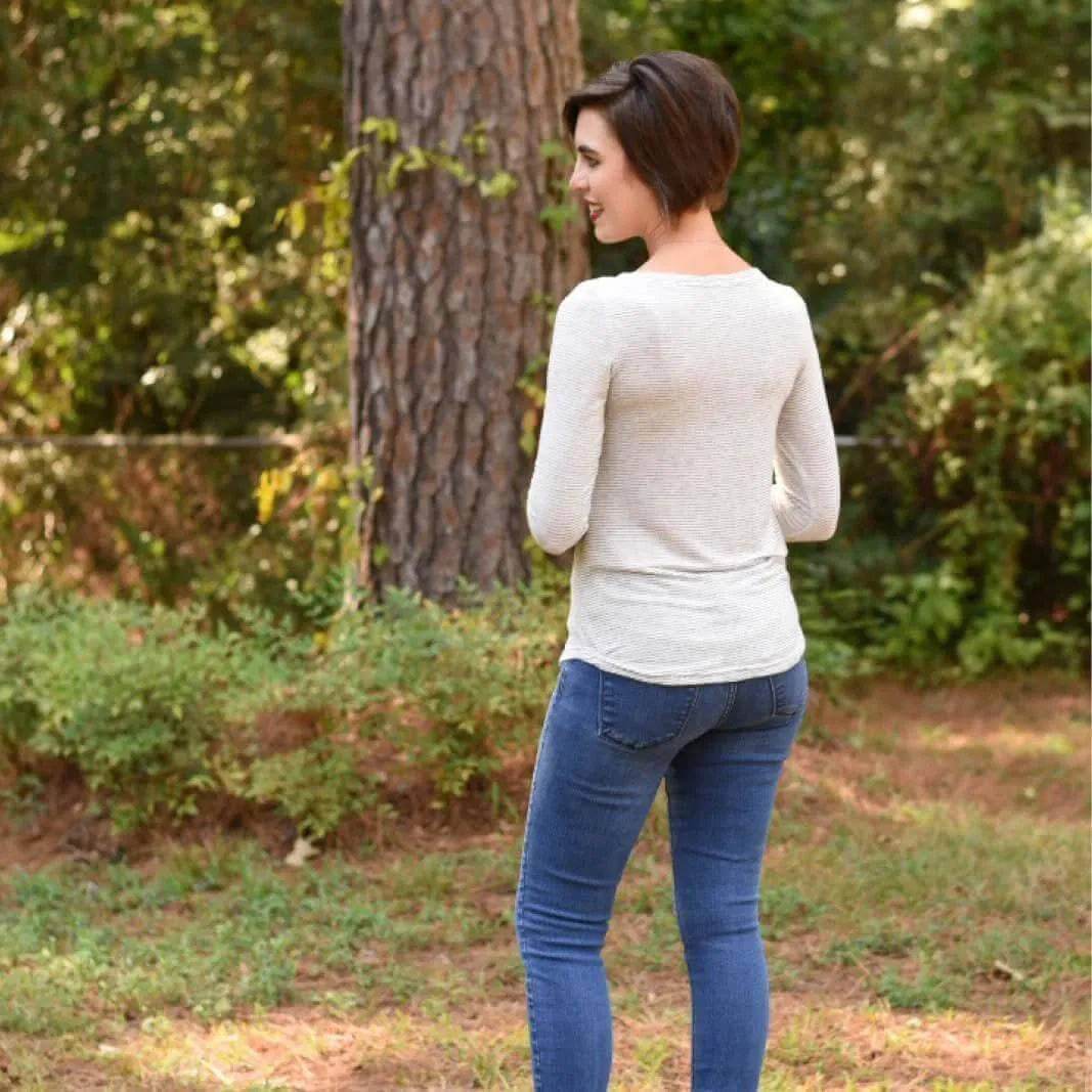 Back view of a woman wearing a casual fitted T-shirt and jeans outdoors, showcasing a stylish appearance.