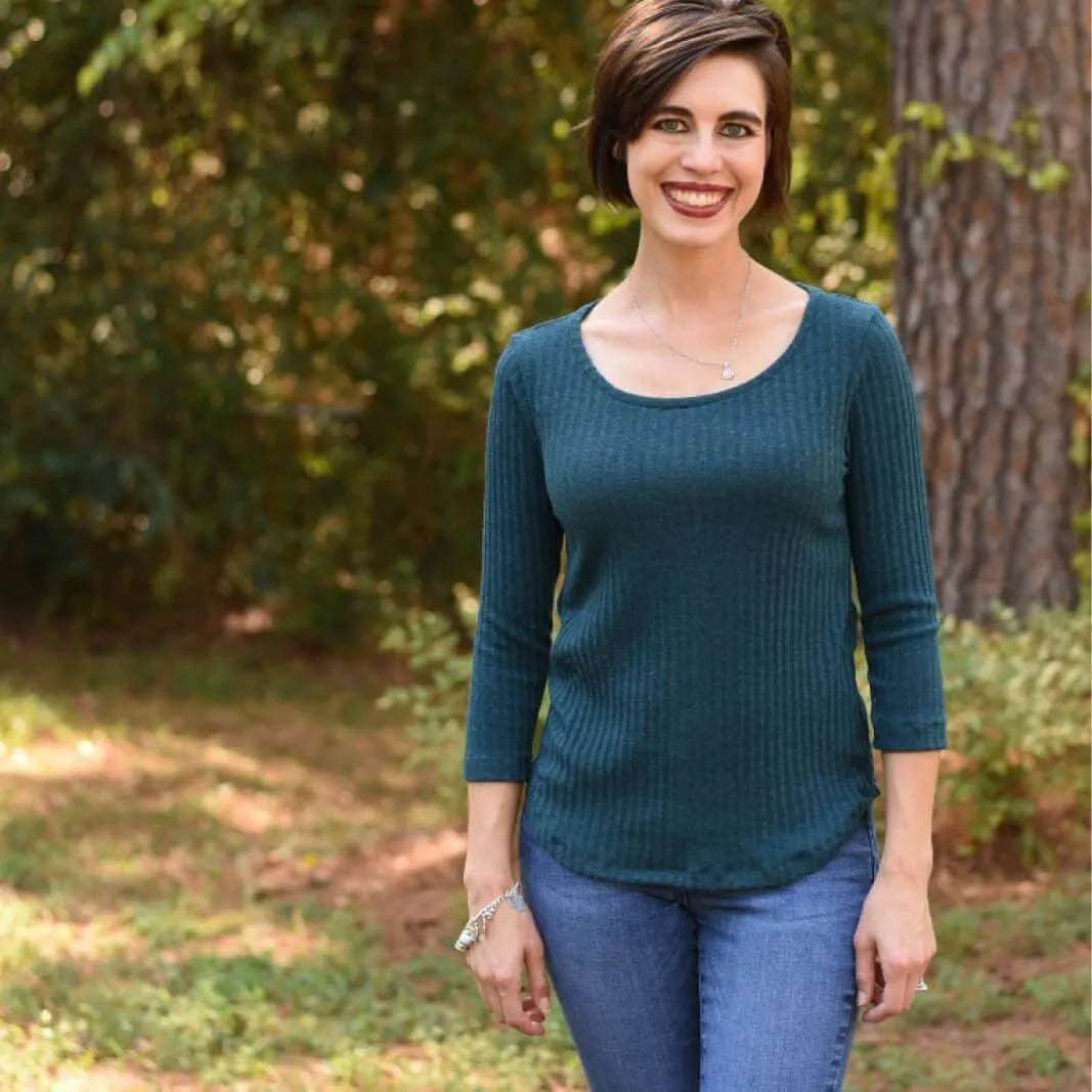 Woman modeling a fitted T-shirt made with the T-shirt Paper Pattern outdoors in a relaxed setting.