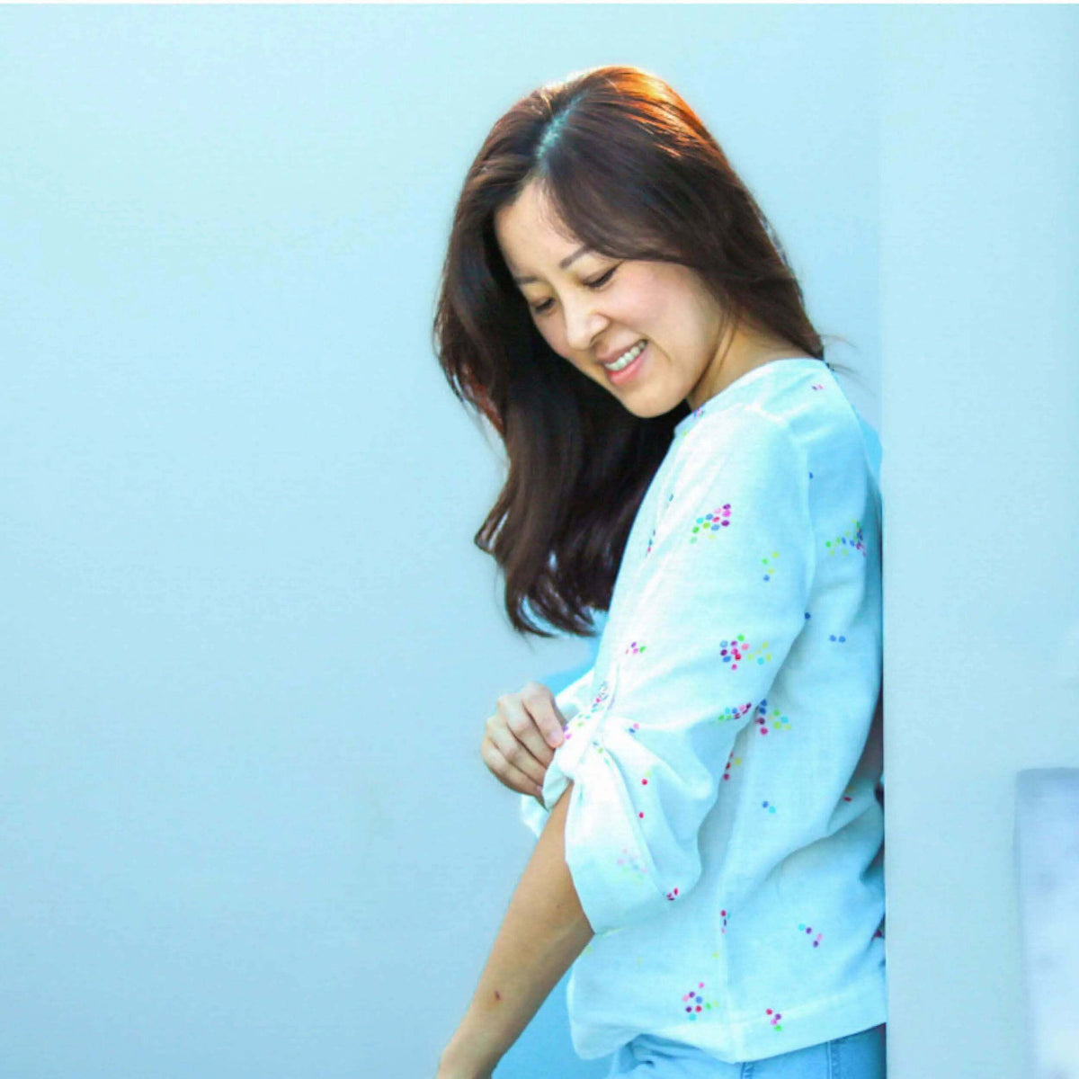 Woman wearing a light blue Whisper blouse Paper Pattern with floral details, showcasing a relaxed fit and breathable fabric.