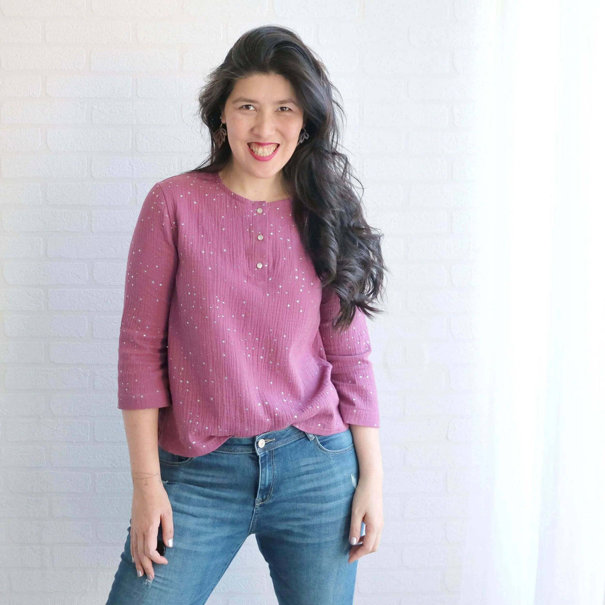 Woman wearing the Whisper blouse Paper Pattern in a pink fabric, highlighting its comfortable fit and style.