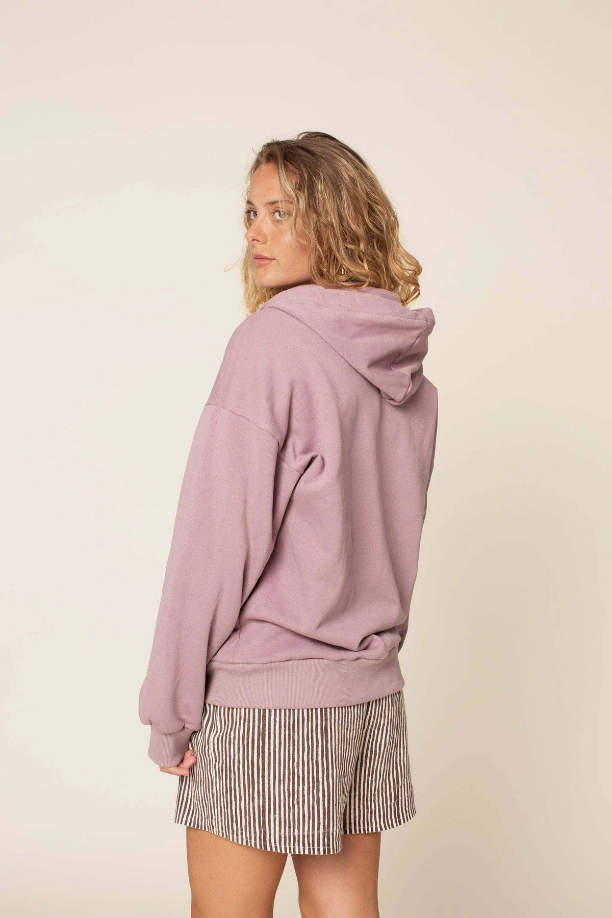 Woman wearing a Zipper hoodie paper pattern in a relaxed fit, showcasing the back view with hood, perfect for layering.