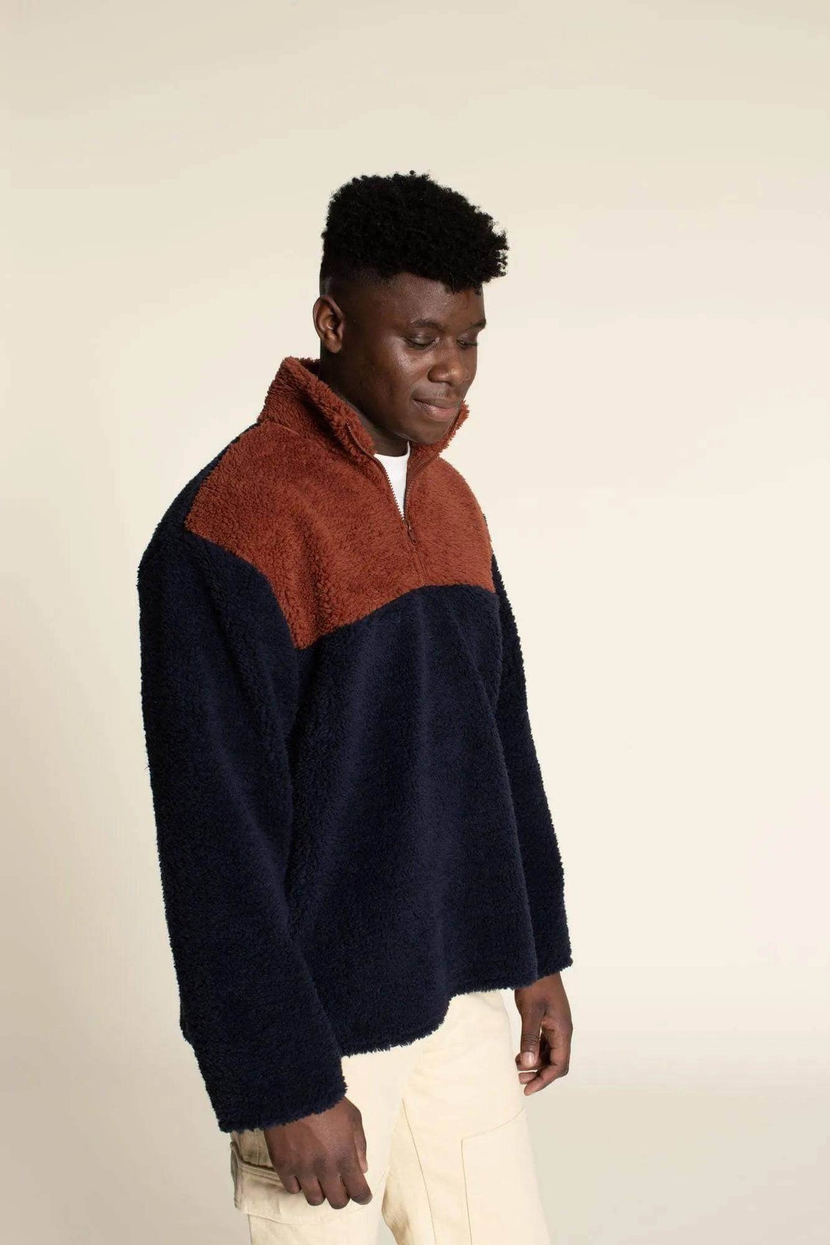 Man wearing a Zip Up Sweater paper pattern with a brown and navy color scheme, featuring a cozy high collar.