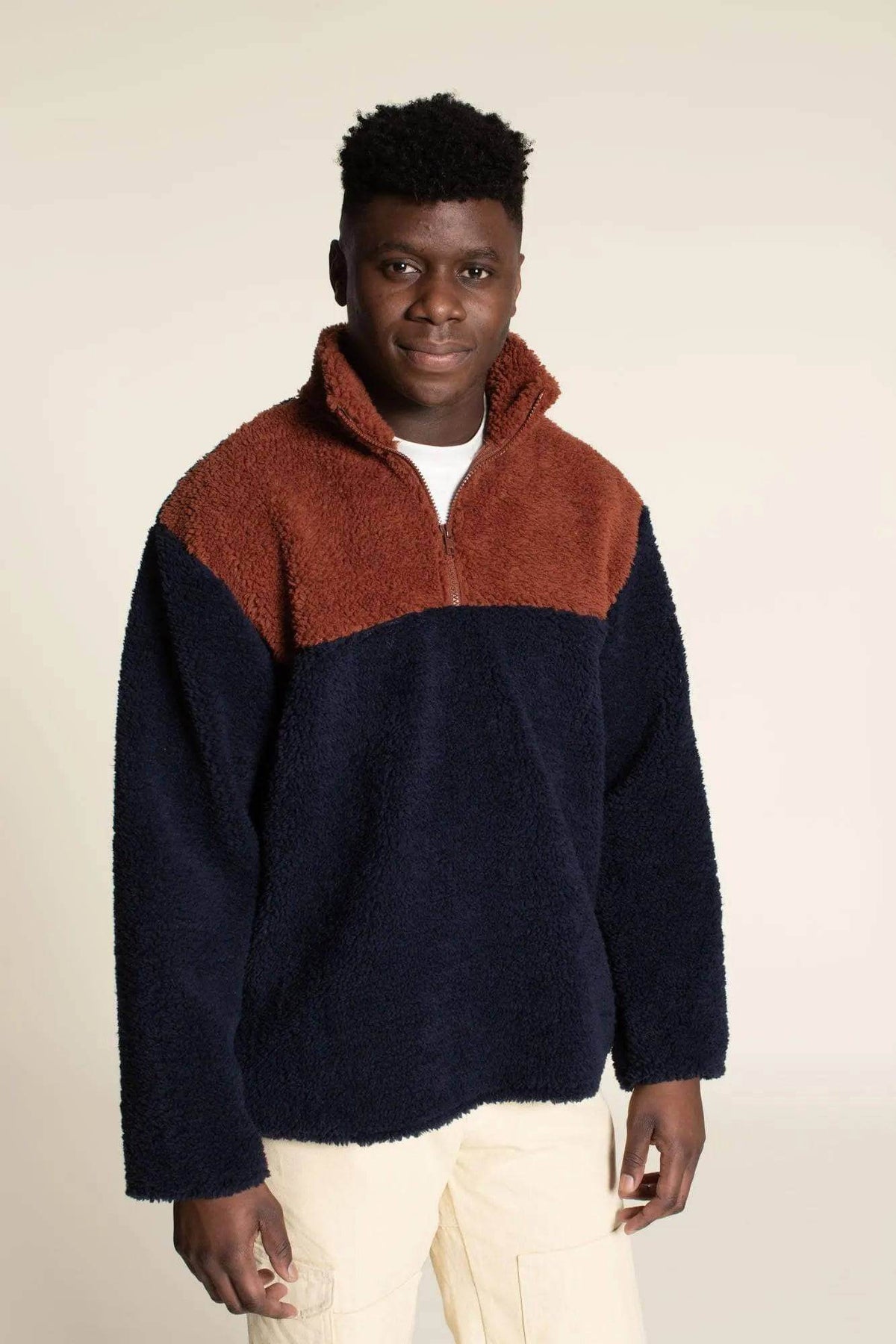 Zip Up Sweater paper pattern displayed by a model in a cozy two-tone design with zip-up front and high collar.