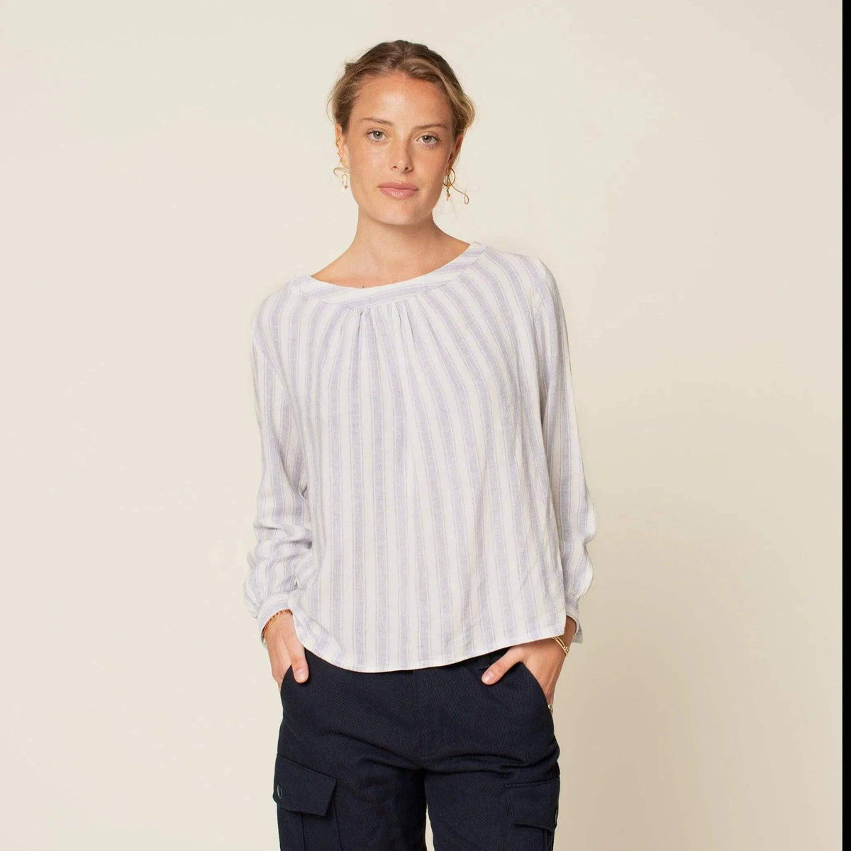 Woman wearing Esther Blouse Paper Pattern, a sweet blouse with gathered neckline and striped fabric.