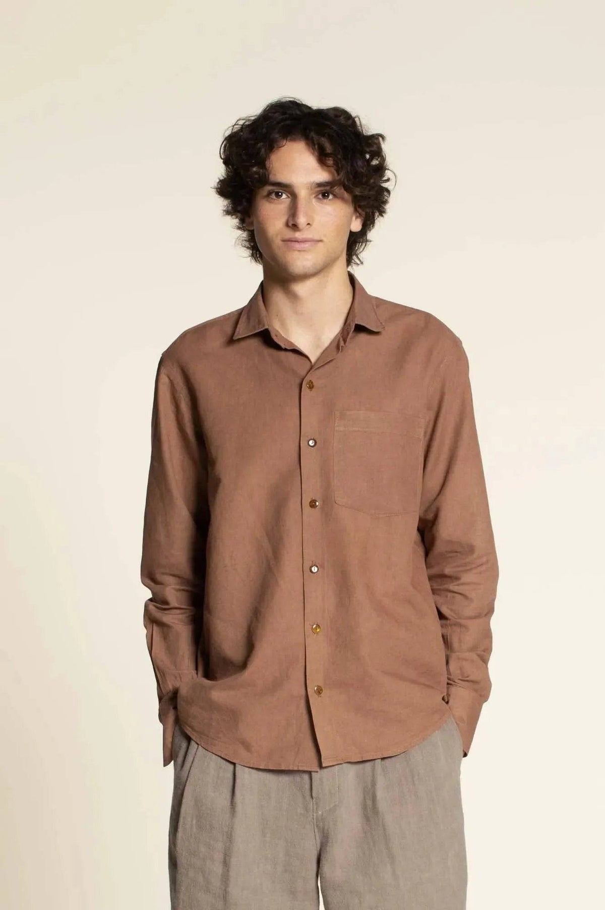 Jensen shirt Paper Pattern model wearing a brown button-up shirt, showcasing collar and front button placket.