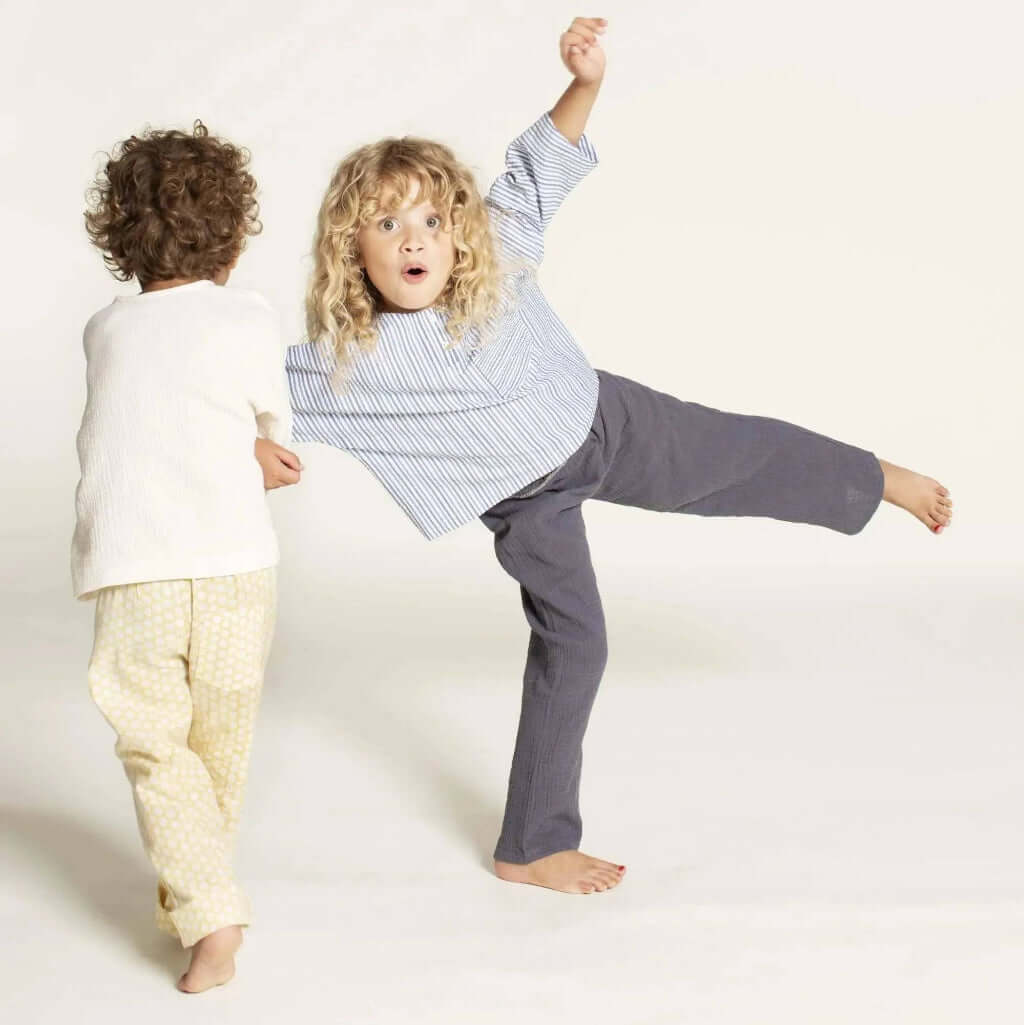 Two children playing wearing a comfortable Una shirt sewing pattern in size 3-12 years with stylish designs.