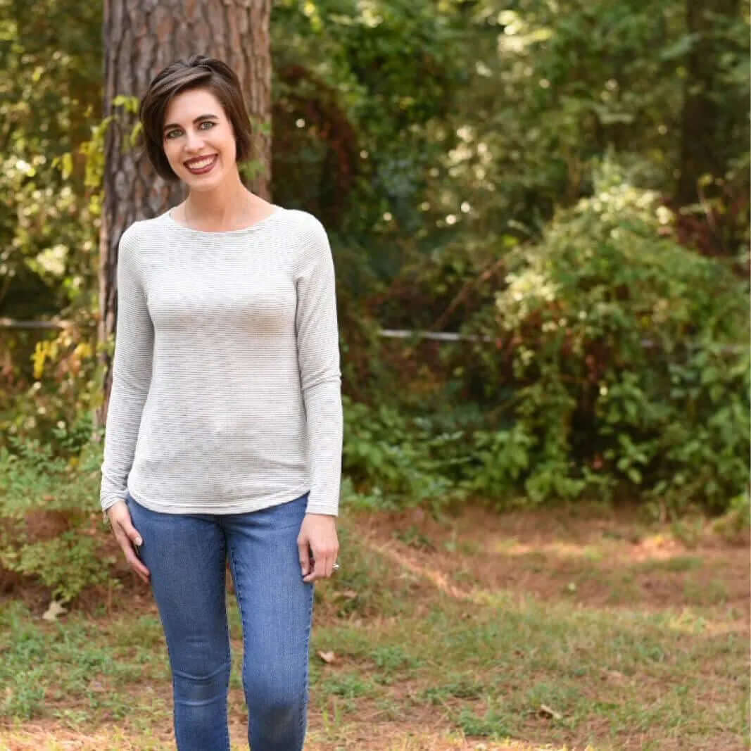 Model wearing a fitted T-shirt made from the T-shirt Paper Pattern, showcasing a stylish outfit in a natural setting.