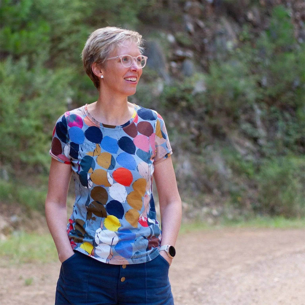 Model wearing a colorful T-shirt made from the T-shirt Paper Pattern, with a mix of circles in various colors.