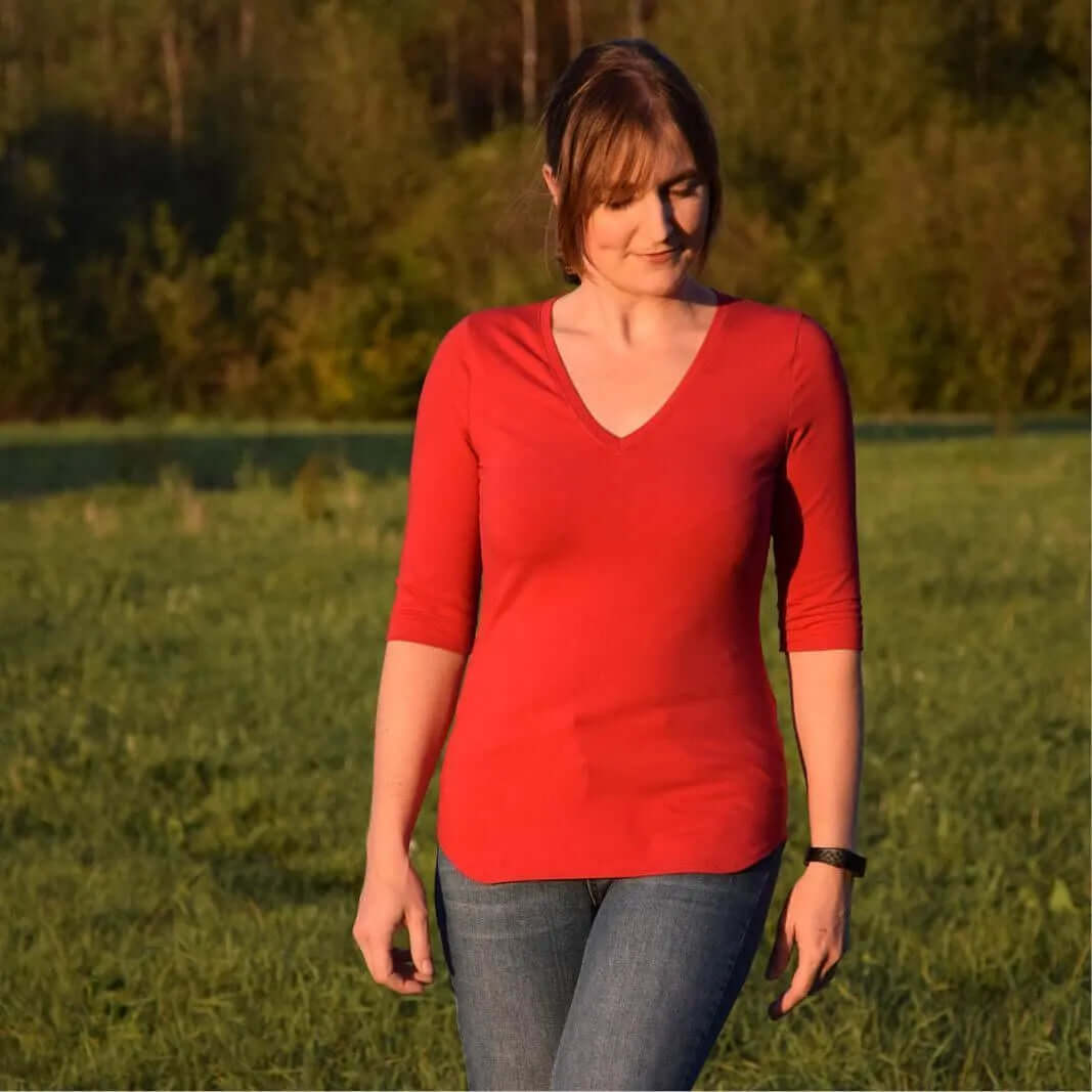 Woman wearing a fitted red T-shirt made from the T-shirt Paper Pattern, showcasing a V-neck and three-quarter sleeves.